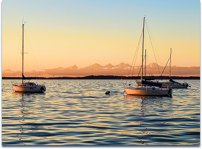 Two boats with sales in Madison lake at dusk